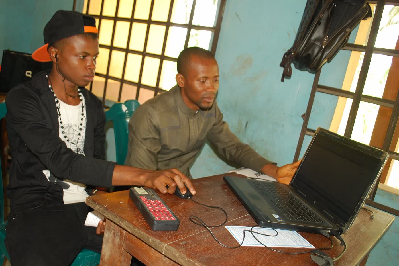 A tutor and a student working at a laptop